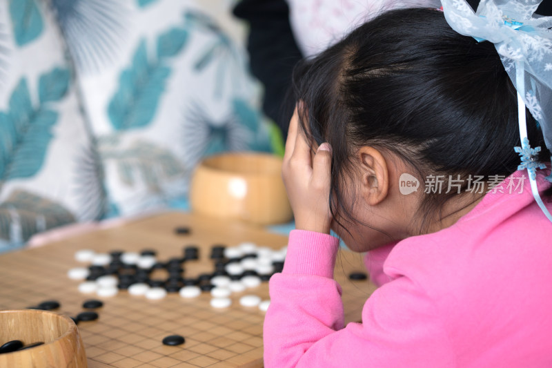 小女孩在思考着下围棋