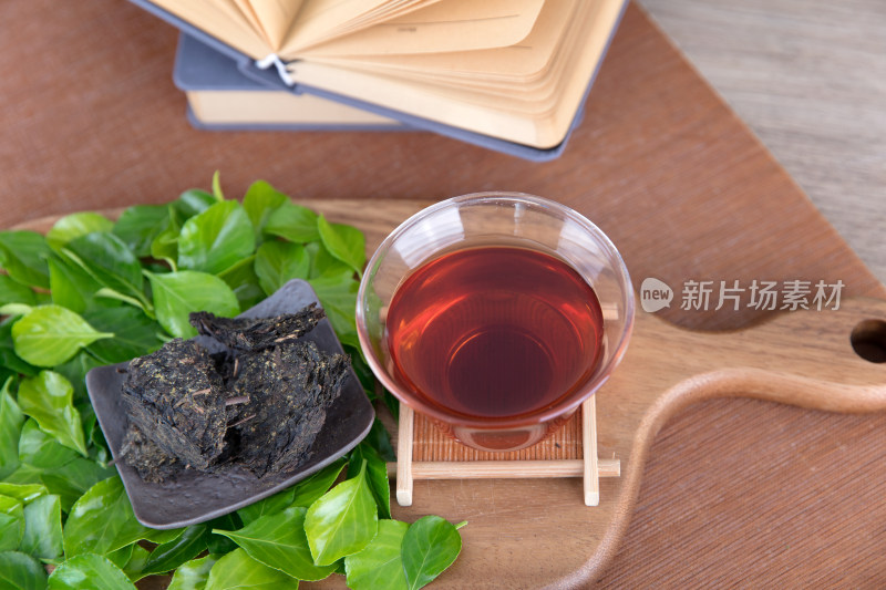 砧板上的茶水和茶叶和铺着的绿叶