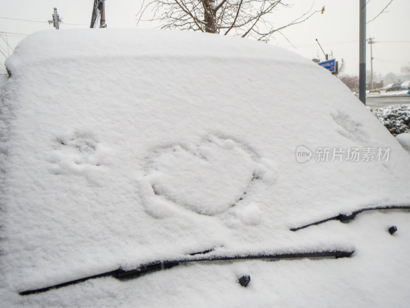 冬天雪花覆盖车上心型图案照片