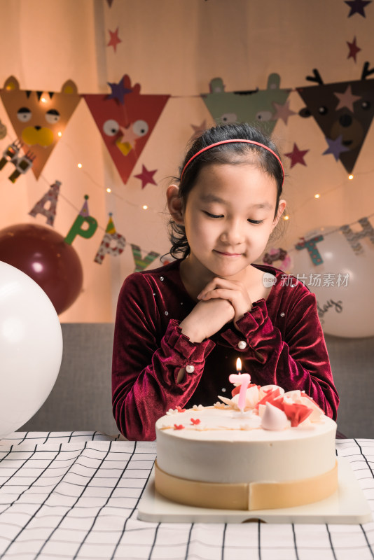 中国女孩对着生日蛋糕许愿吹蜡烛