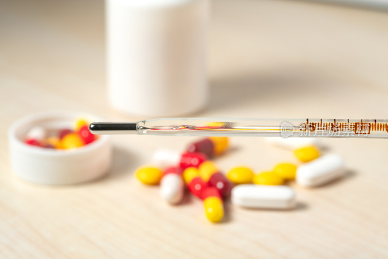 桌面上的体温计与多种药片