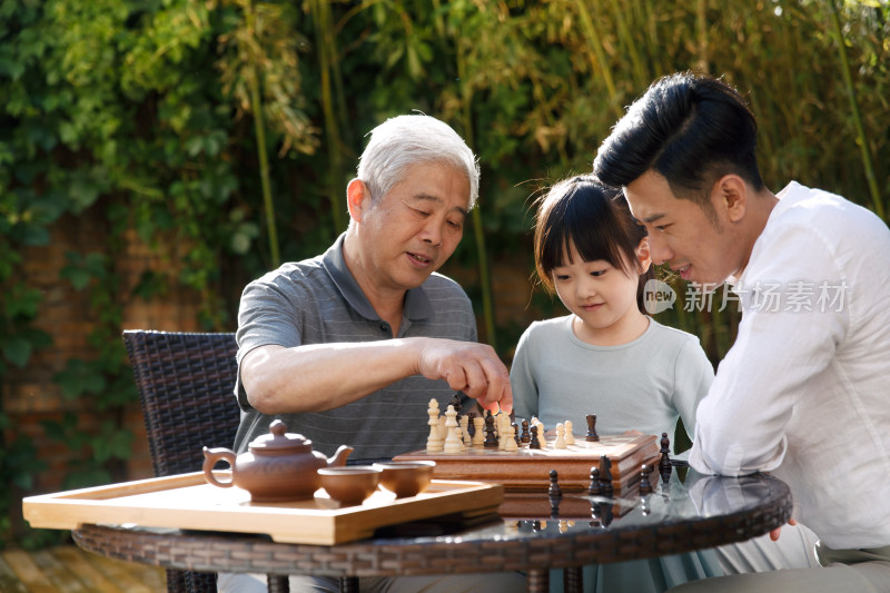 祖孙三代在庭院里下棋