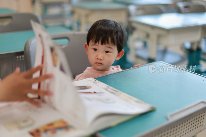 可爱的女孩在教室里看书