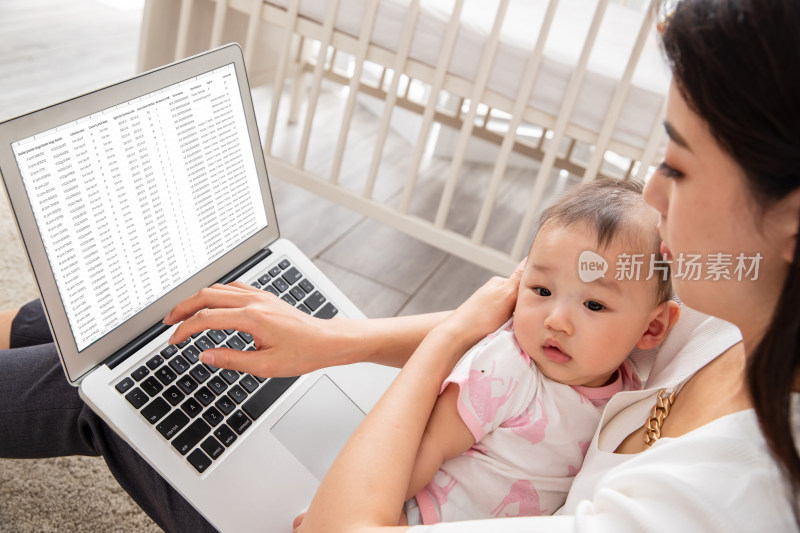 年轻妈妈带着宝宝看电脑