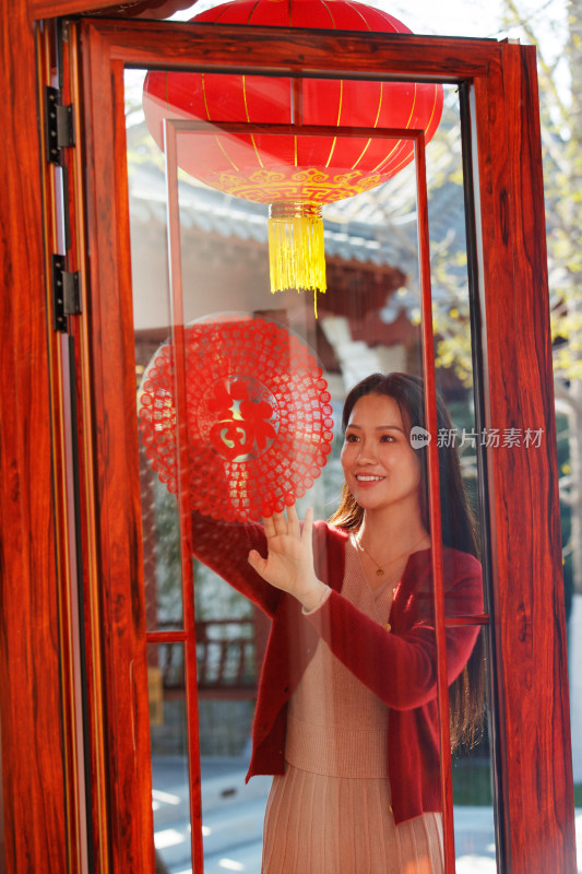 年轻女人过年贴窗花