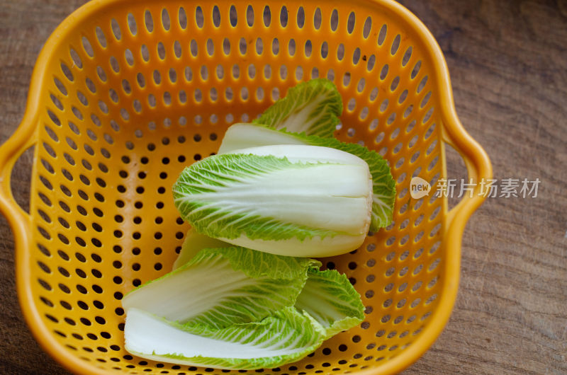 黄色沥水篮中的新鲜小白菜