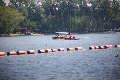 湖面上行驶的船只与岸边树林
