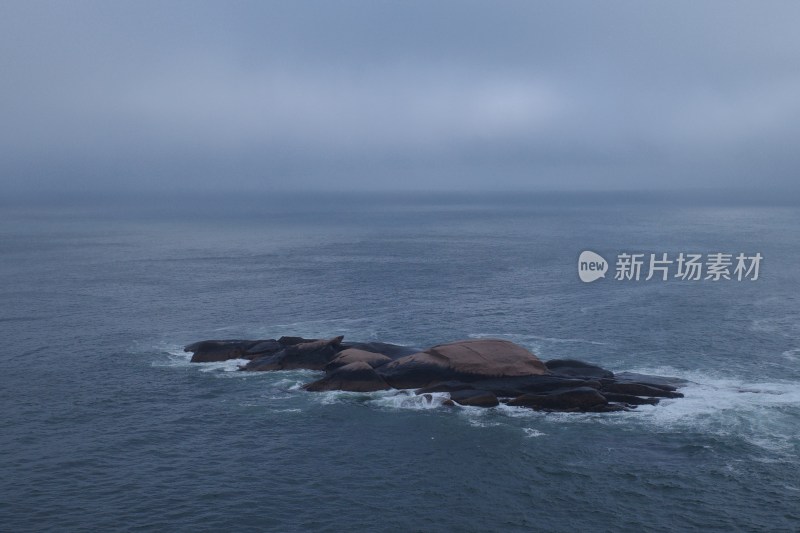 阴云笼罩下的海面及礁石景象