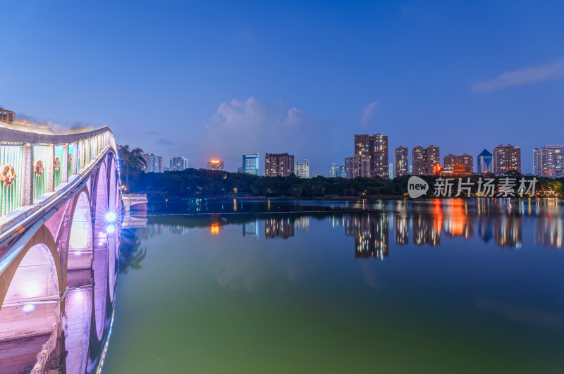 南宁南湖公园石拱桥与城市摩天大楼夜景灯光