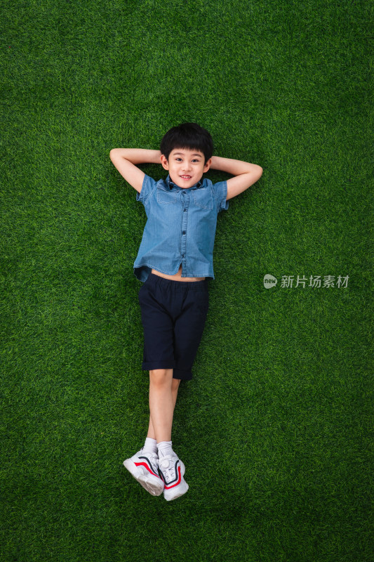 可爱的小男孩躺在草地上