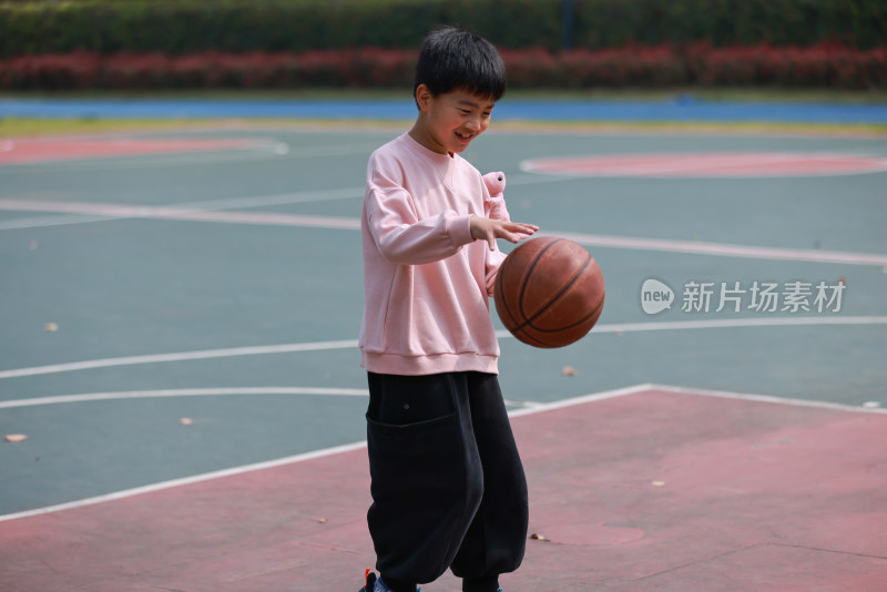 亚洲男孩在校园里练习打篮球