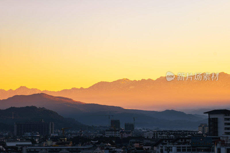 城市中遥望被夕阳映照的连绵山脉