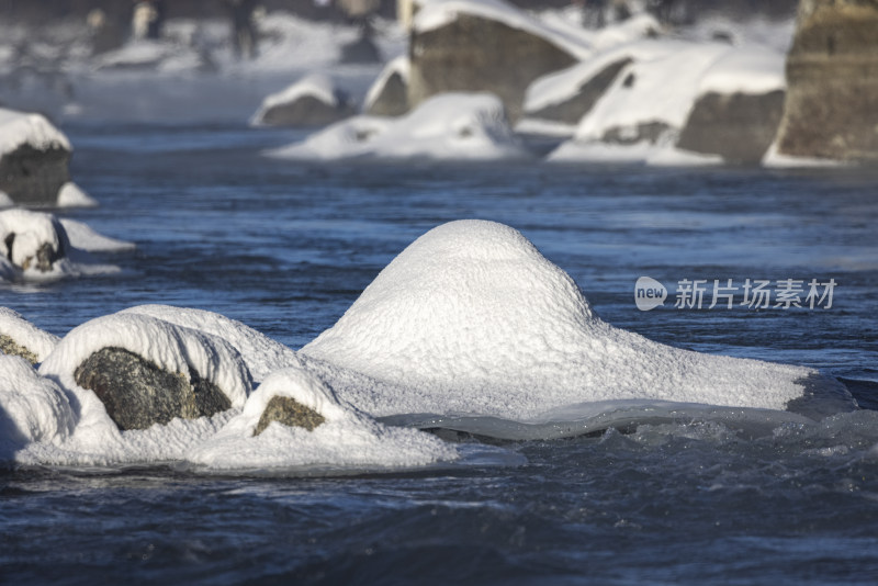 冬日新疆喀纳斯湖面岩石被雪覆盖