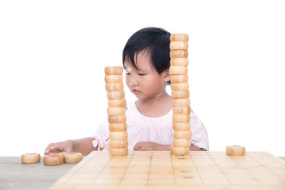 在白背景前的桌子上摞中国象棋棋子