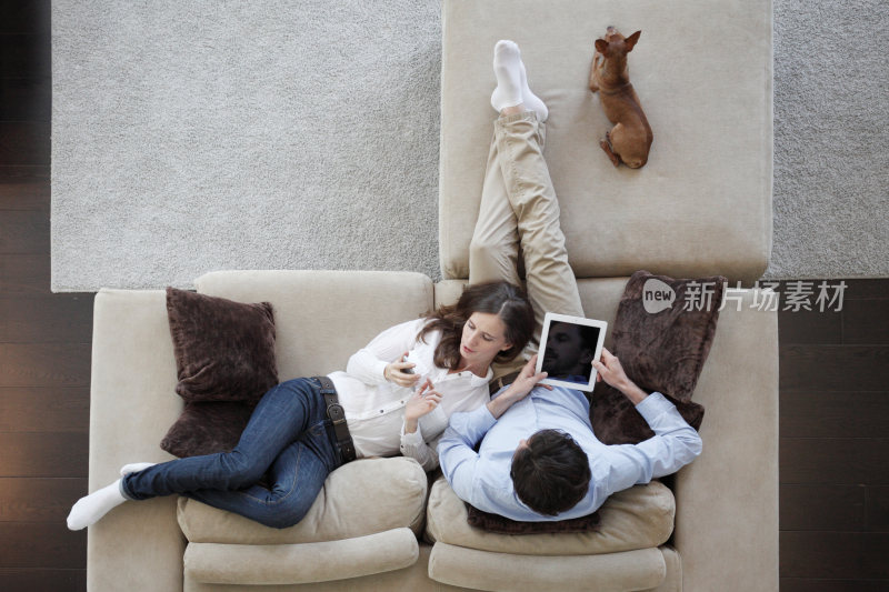 情侣沙发上休闲使用电子设备