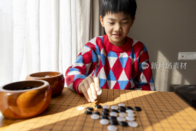 中国小孩在窗边下棋围棋