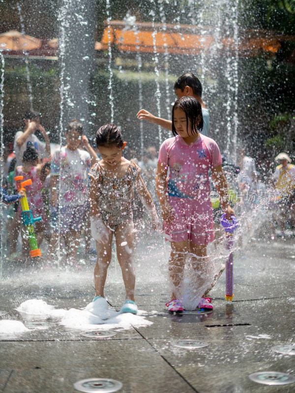 暑假小朋友在地面喷泉玩水清凉特写
