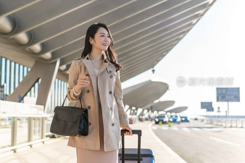 商务女士在机场拉着行李箱