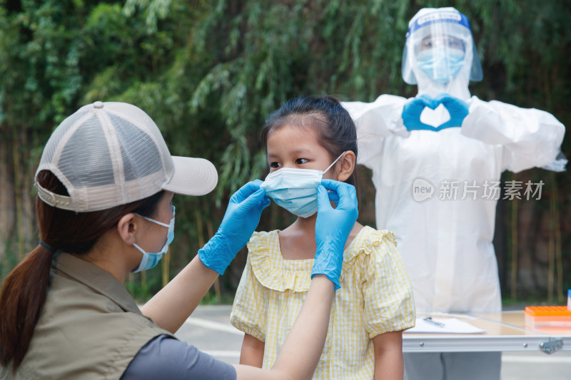 社区志愿者帮小女孩戴口罩