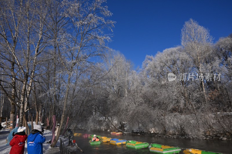 冬季河岸树木挂霜 水面漂着多彩皮筏艇