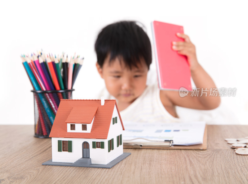 中国小女孩正在玩弄着桌子上的小房子模型