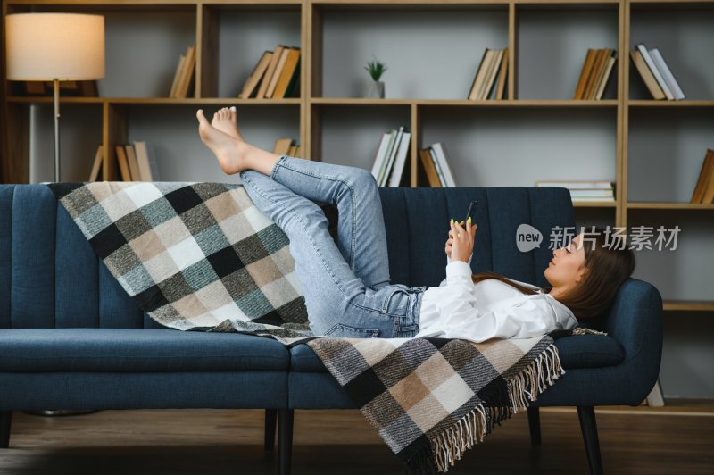 女子沙发上放松玩手机