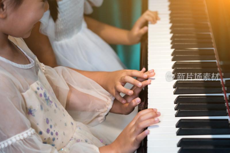 两个弹奏钢琴的女孩手部特写