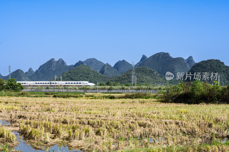 万里无云天空下桂林山边铁路上的高速列车