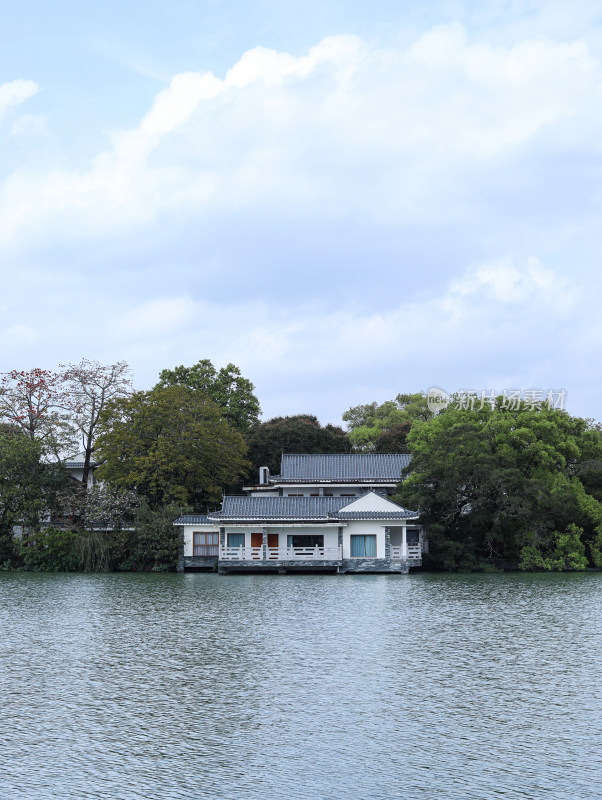 春天，蓝天白云下的湖面和房子树木自然风景