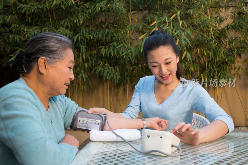 年轻女人给老年女人量血压