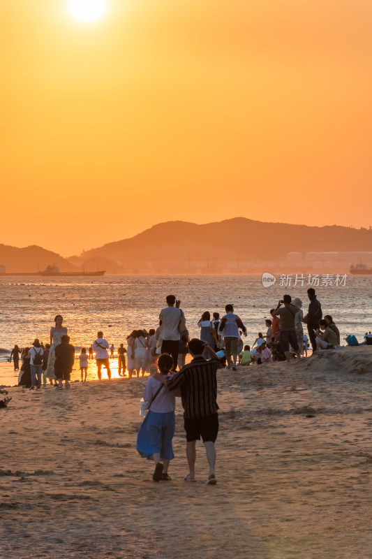 海边夕阳下的人群休闲场景