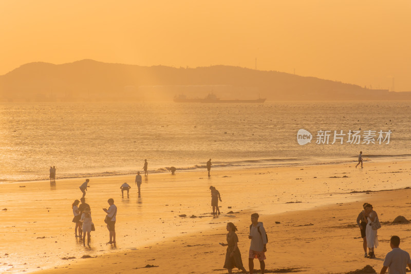 海边夕阳下的人群休闲场景