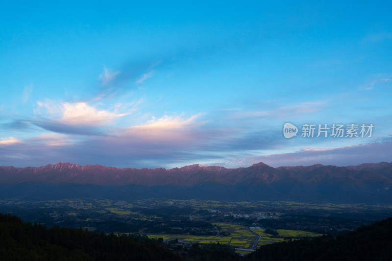 高黎贡山下的村庄与大片油菜花田的远景