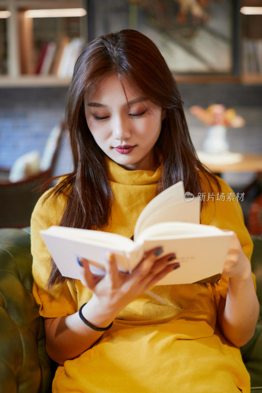 在图书咖啡馆阅读书籍的少女