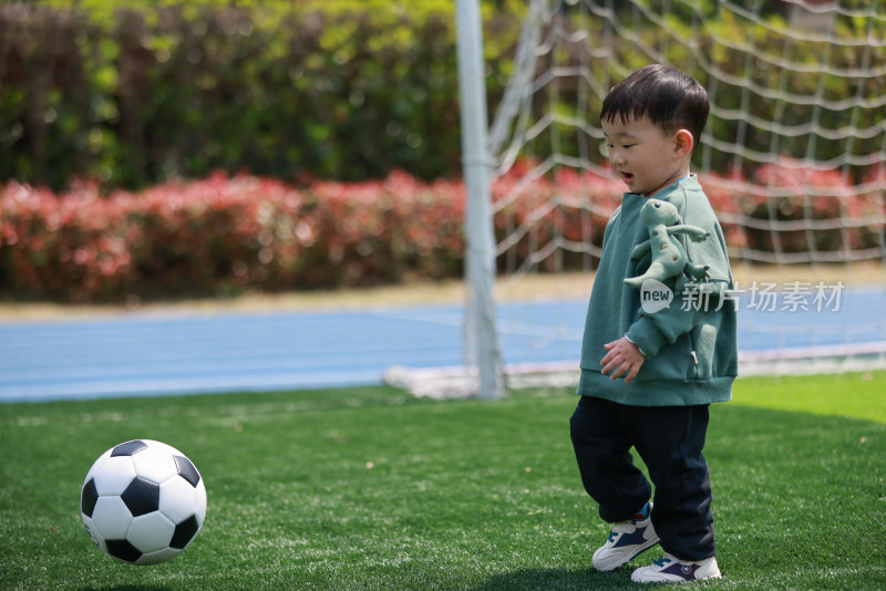 可爱的男孩在足球场上玩耍