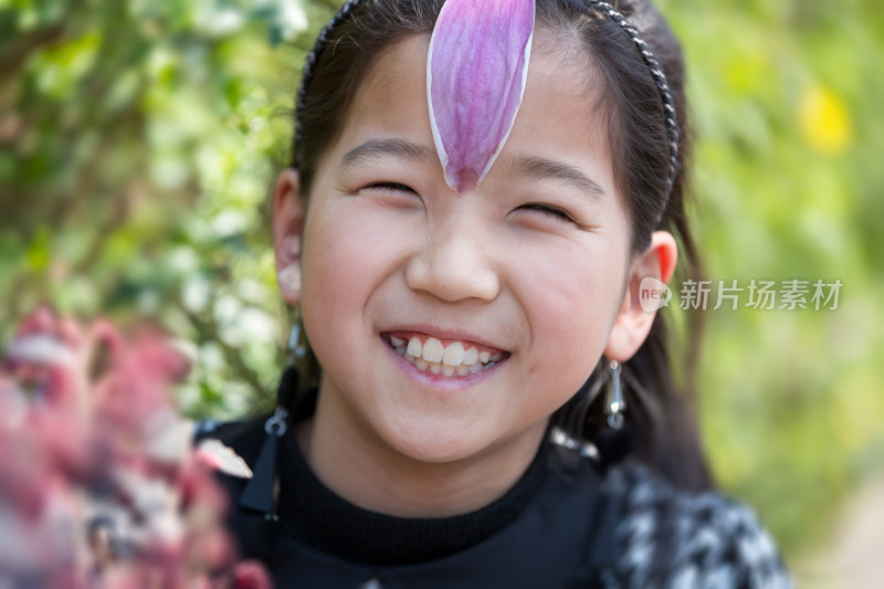 脑门上贴着花瓣的微笑可爱中国女孩