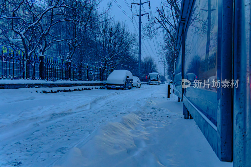 雪天夜晚亮灯的居民楼外景马路街道