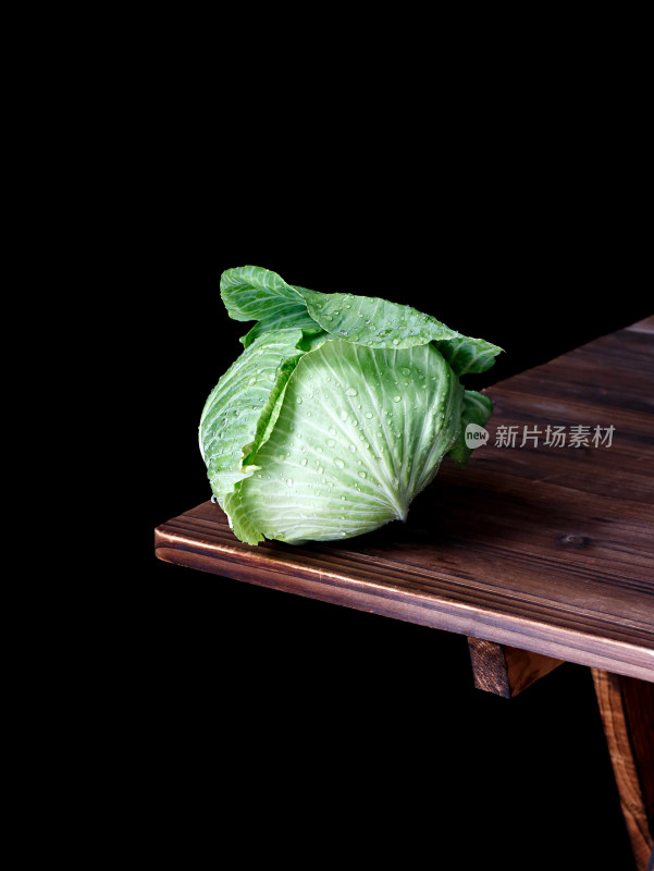 木桌角上摆放着一个绿色蔬菜包菜卷心菜