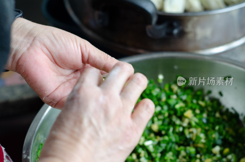 正在包韭菜鸡蛋饺子的女人的手特写