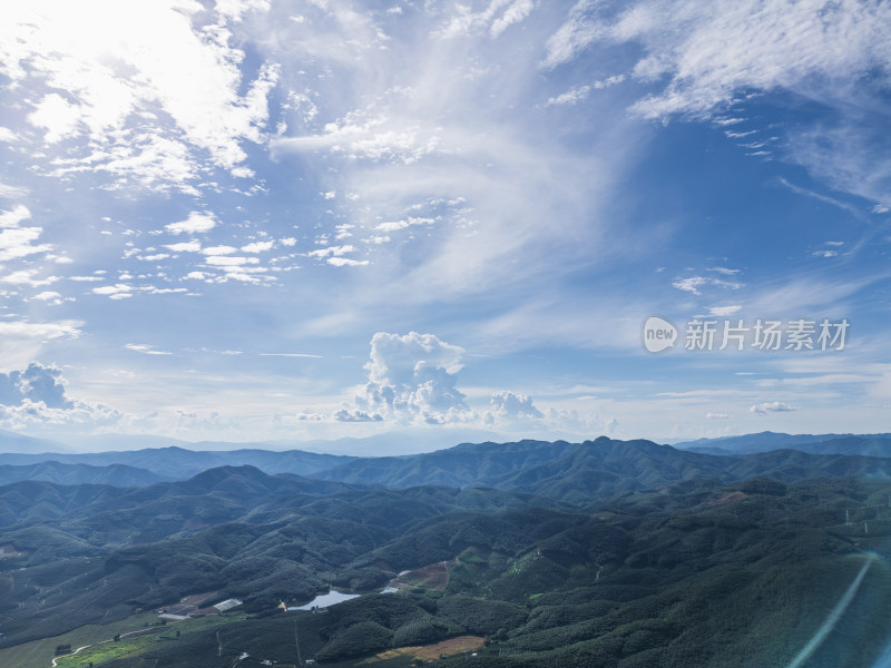 航拍蓝天白云下的绿色山脉