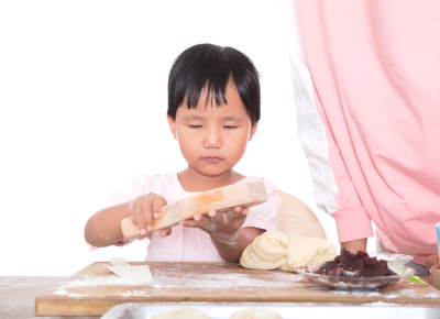 中国小女孩在向妈妈学习做中秋节的月饼