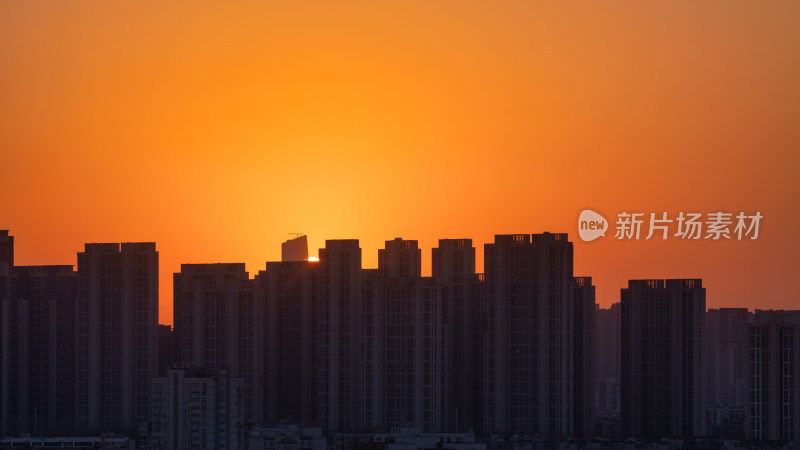 清晨城市高层住宅与日出太阳