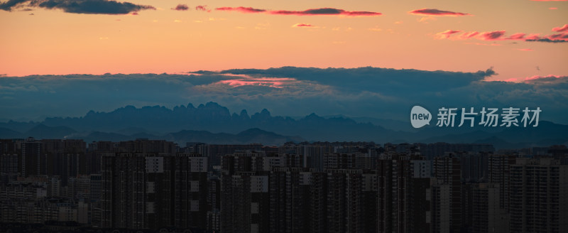 城市高楼与晚霞山脉景观