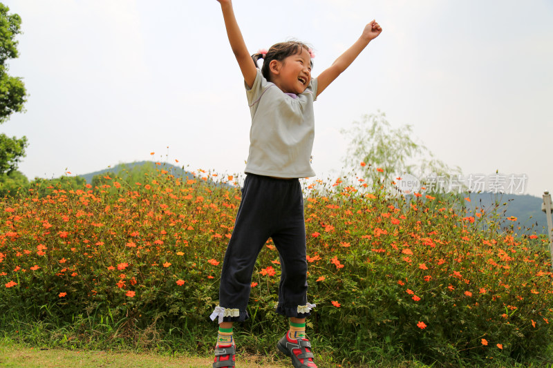 小女孩花丛中欢呼跳跃