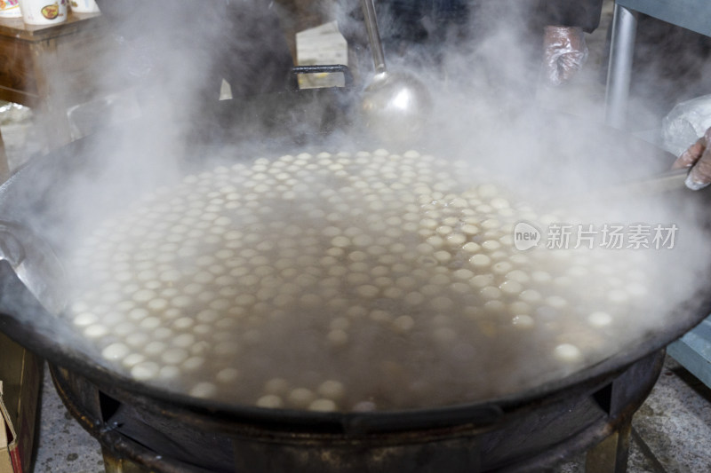 大锅中煮着大量白色汤圆