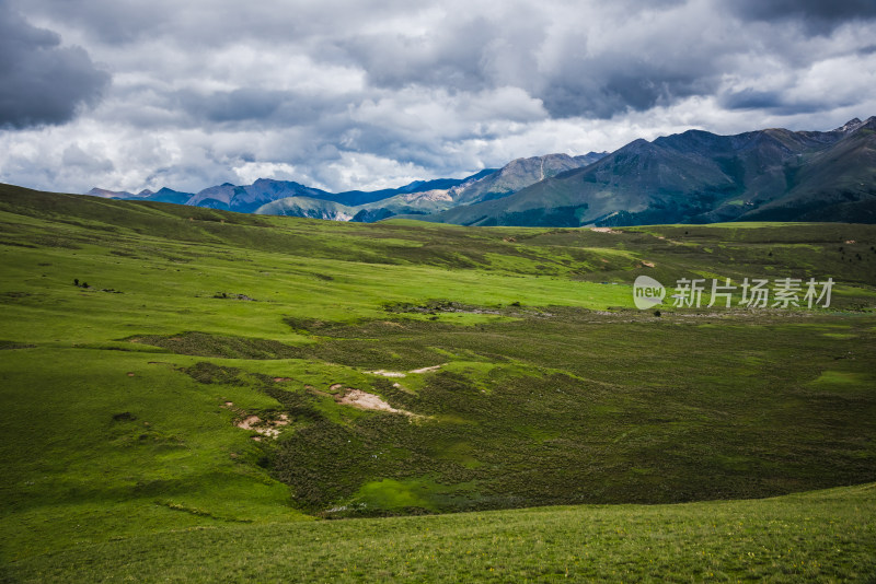 蓝天白云下广袤草原与连绵山峦自然风景