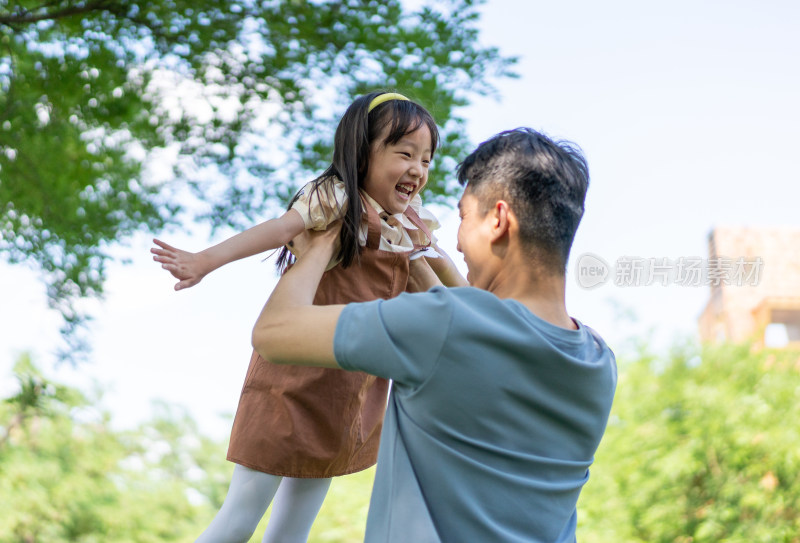 爸爸抱起女儿张开双臂转圈旋转