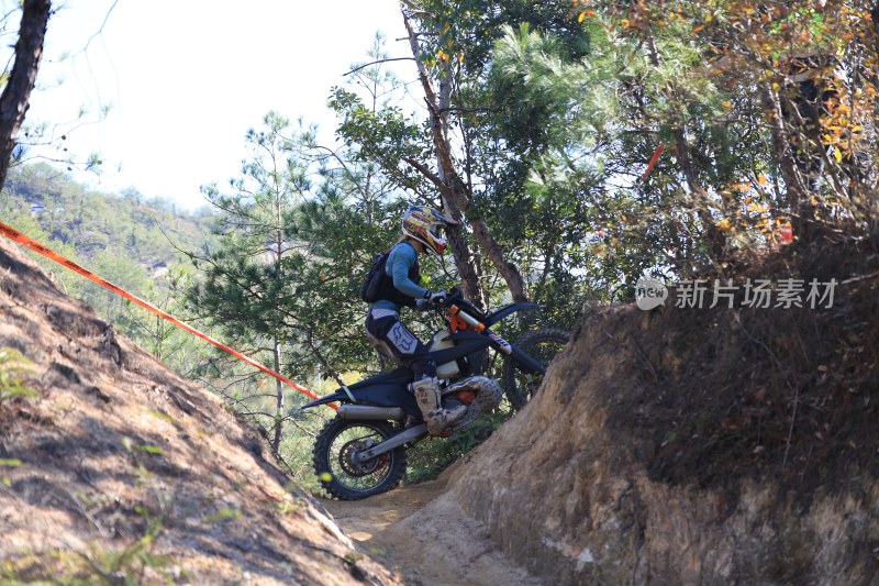 越野摩托车骑手沙土坑上坡