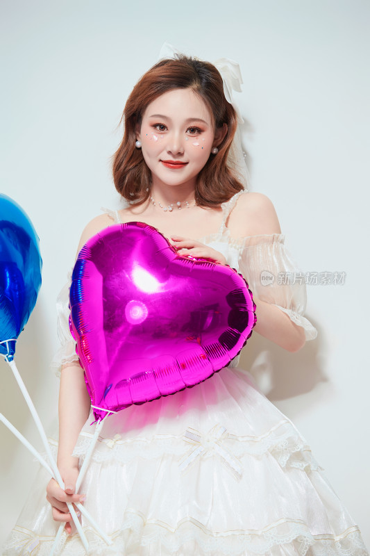 穿着公主裙手拿气球庆祝生日的亚洲女性