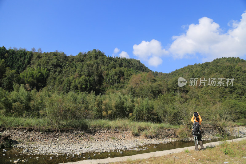 山林徒步者用手机拍摄美景的背景